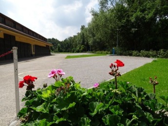 Einfahrt mit Blumen an der Remise