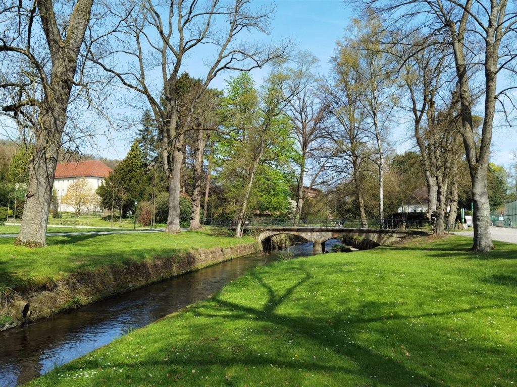 die Aue mit der alten Steinbrücke, rechts im Bild der Tennisplatz